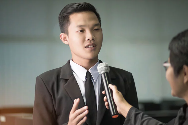 young man in corporate attire delivering a speech