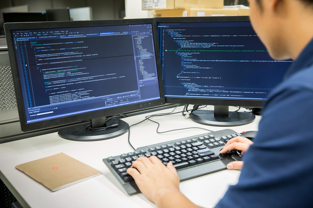 male student doing code programming using a computer