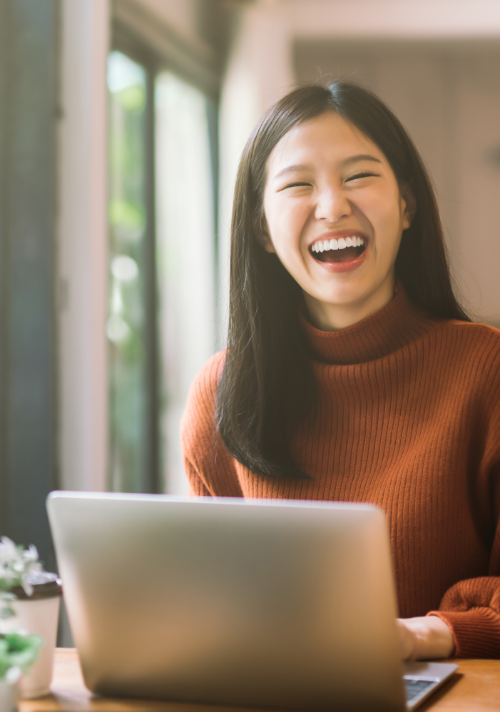 happy young woman looking at her laptop screen