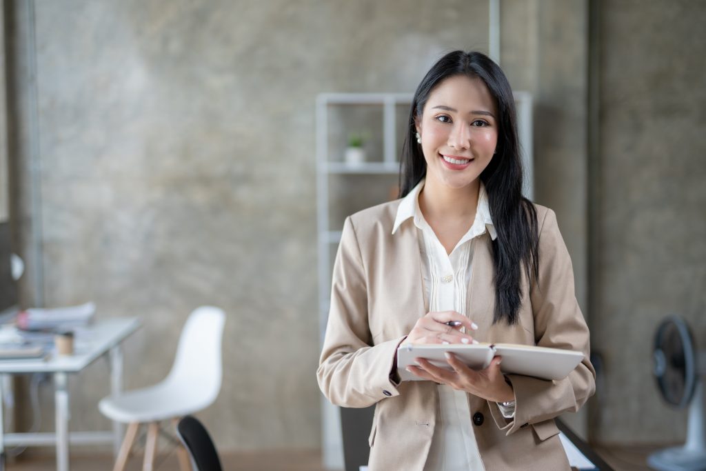 a woman standing carrying a notebook