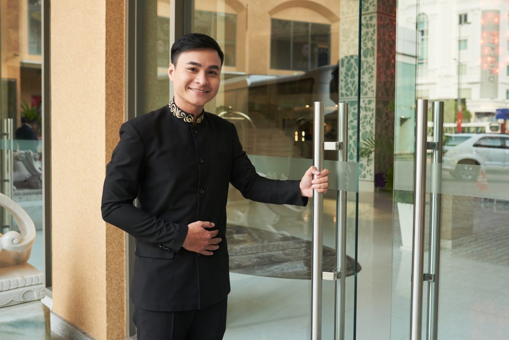 a hotel worker holding the door