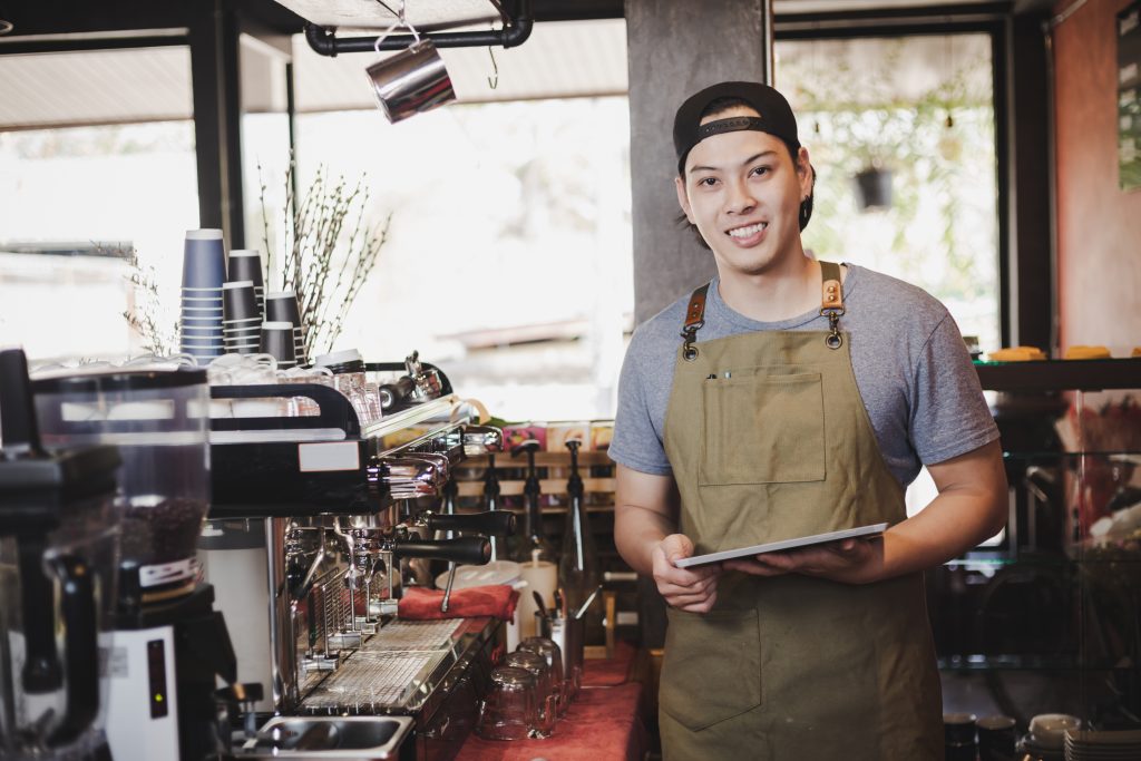 a cafe owner holding a tablet