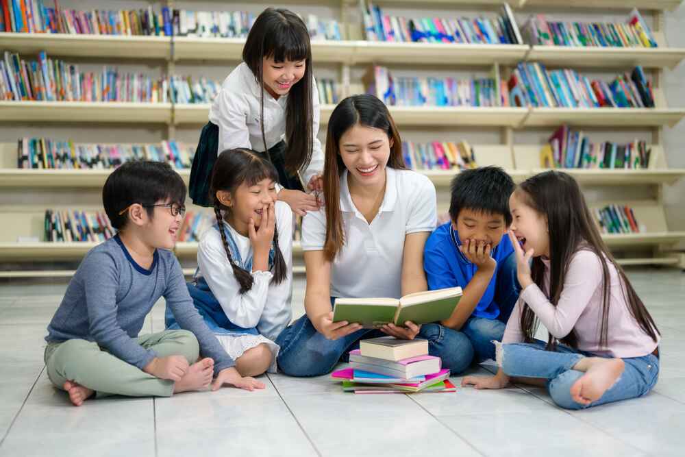 a teacher reading a book to her students