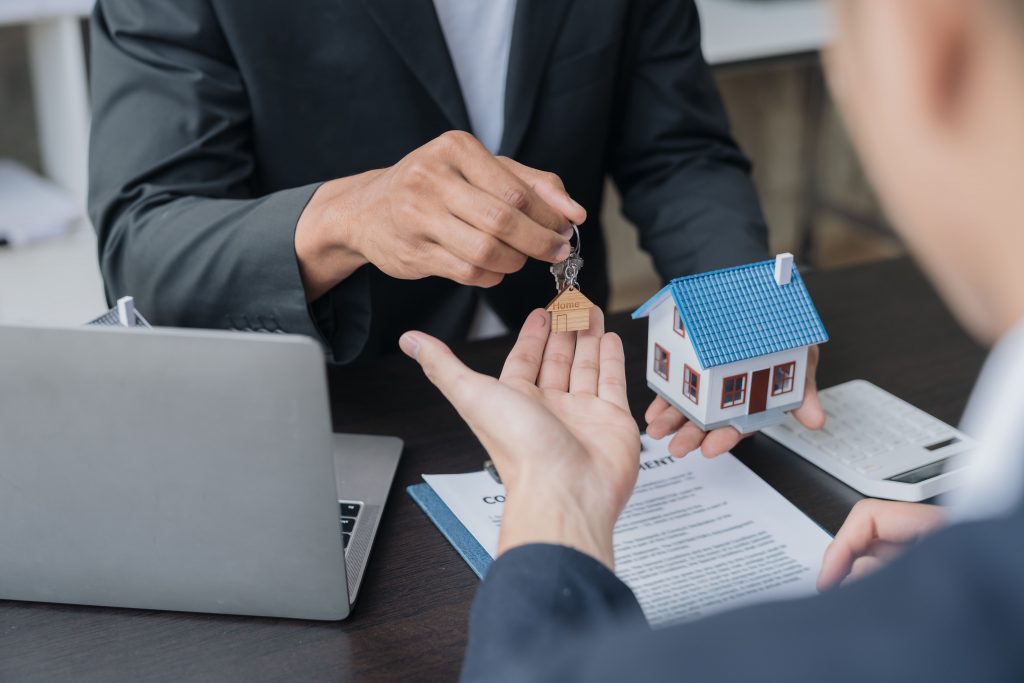 a real estate broker handing keys to his client