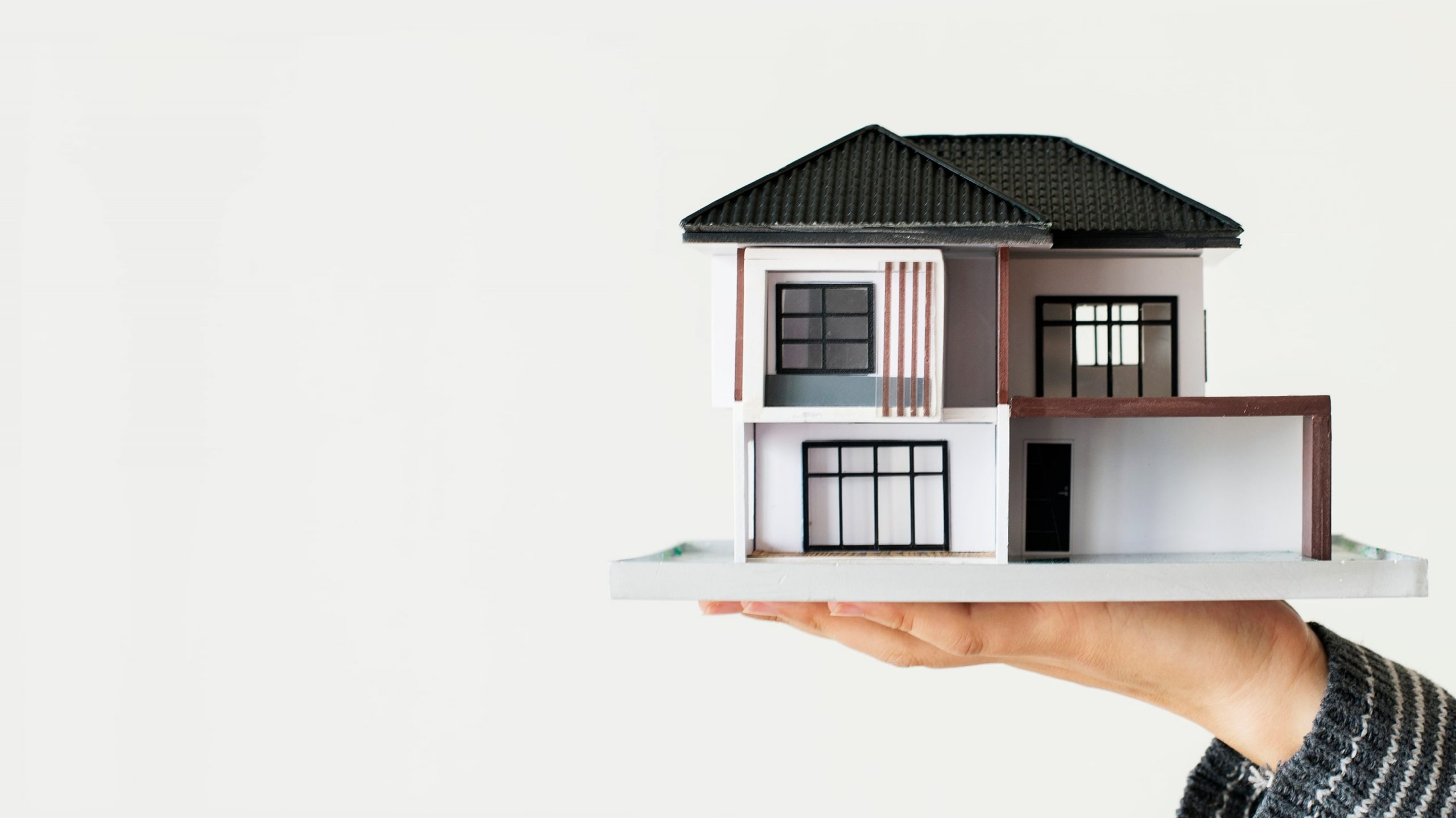 a mini house model sitting on a person's palm