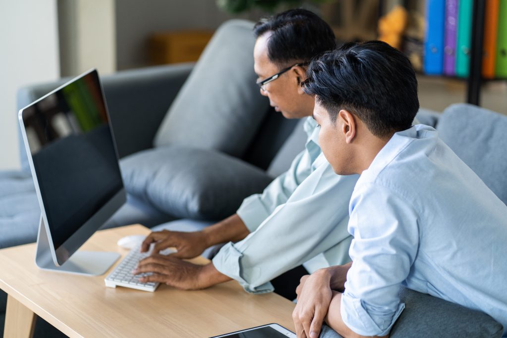 a father and son using a computer